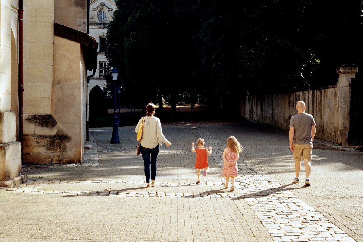 Una familia camina por una calle empedrada de una ciudad europea